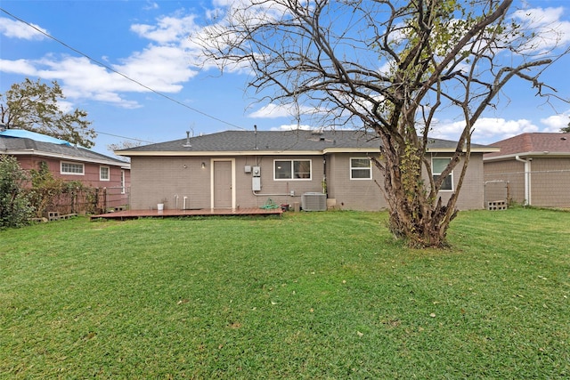 back of property featuring central air condition unit, a deck, and a lawn