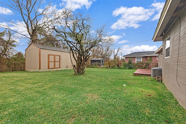 view of yard with a deck, central AC, and a shed