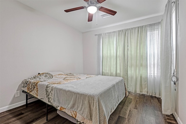 bedroom with dark hardwood / wood-style flooring and ceiling fan