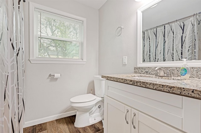 bathroom featuring wood-type flooring, vanity, and toilet