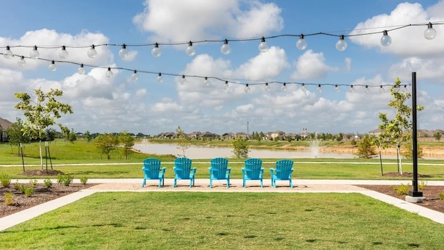 view of property's community with a water view and a lawn