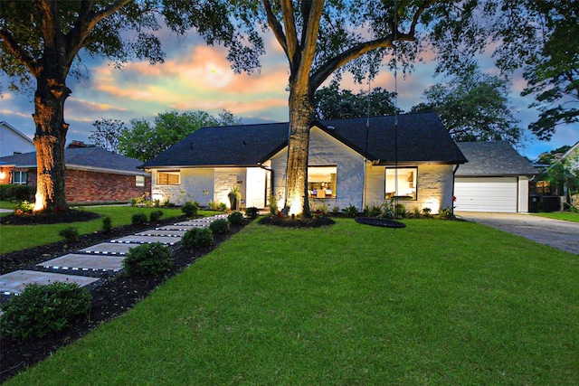 view of front of home with a garage and a lawn