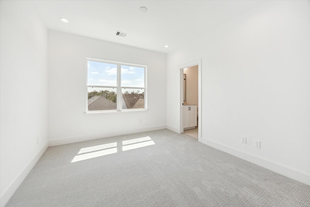 unfurnished room featuring light carpet, baseboards, visible vents, and recessed lighting