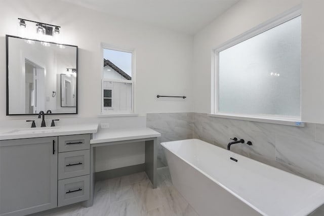 bathroom with a tub, plenty of natural light, and vanity