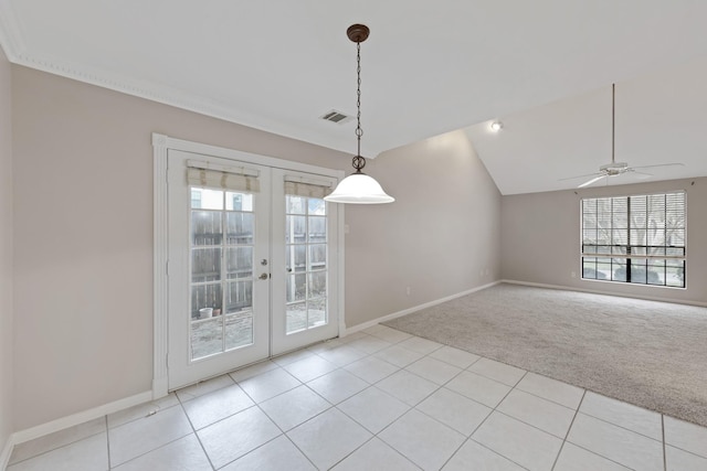 unfurnished dining area featuring lofted ceiling, french doors, a healthy amount of sunlight, ceiling fan, and light colored carpet