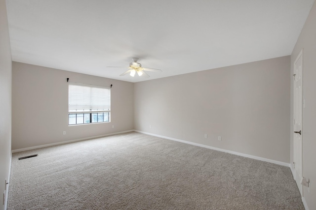 unfurnished room with ceiling fan and light carpet