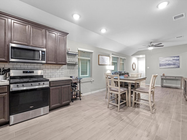 kitchen featuring vaulted ceiling, decorative backsplash, appliances with stainless steel finishes, ceiling fan, and dark brown cabinets