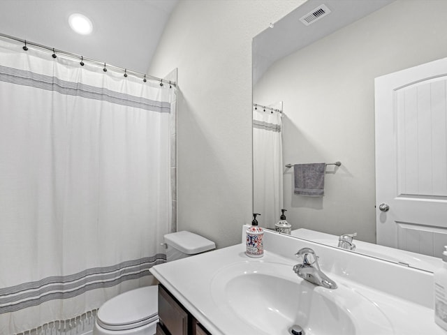 bathroom featuring lofted ceiling, toilet, and vanity