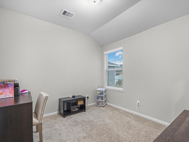 home office with vaulted ceiling and light colored carpet