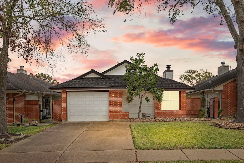 ranch-style home with a garage and a yard