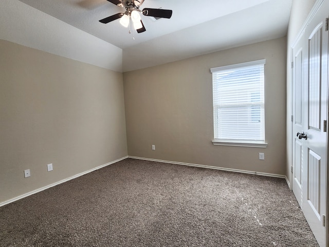 carpeted empty room featuring vaulted ceiling and ceiling fan