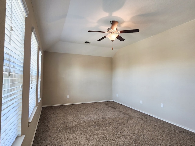 carpeted spare room with ceiling fan and vaulted ceiling