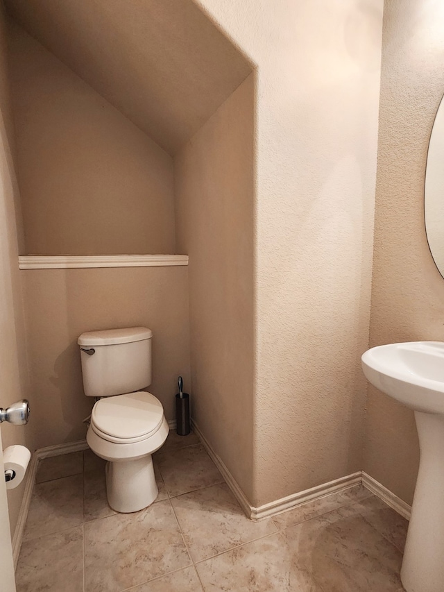 bathroom with toilet and vaulted ceiling