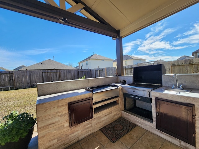 view of patio / terrace with exterior kitchen, sink, and a gazebo