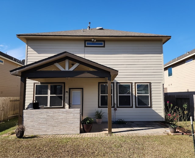 back of property featuring a lawn and a patio