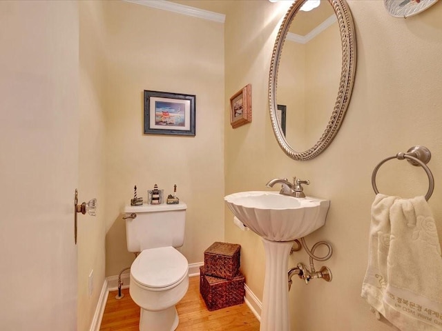 bathroom featuring toilet, sink, hardwood / wood-style floors, and crown molding