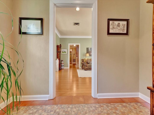 corridor featuring light tile patterned flooring and crown molding