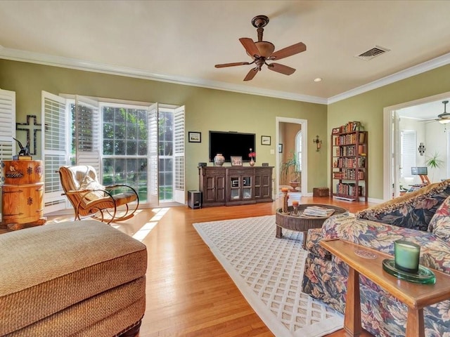 living room featuring ceiling fan, light hardwood / wood-style floors, and crown molding