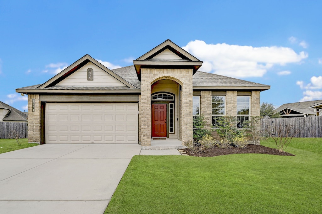 ranch-style house with a garage and a front yard