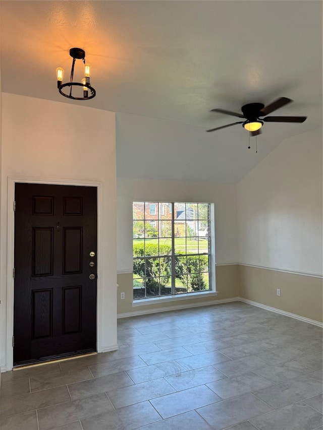 foyer entrance featuring ceiling fan with notable chandelier and vaulted ceiling