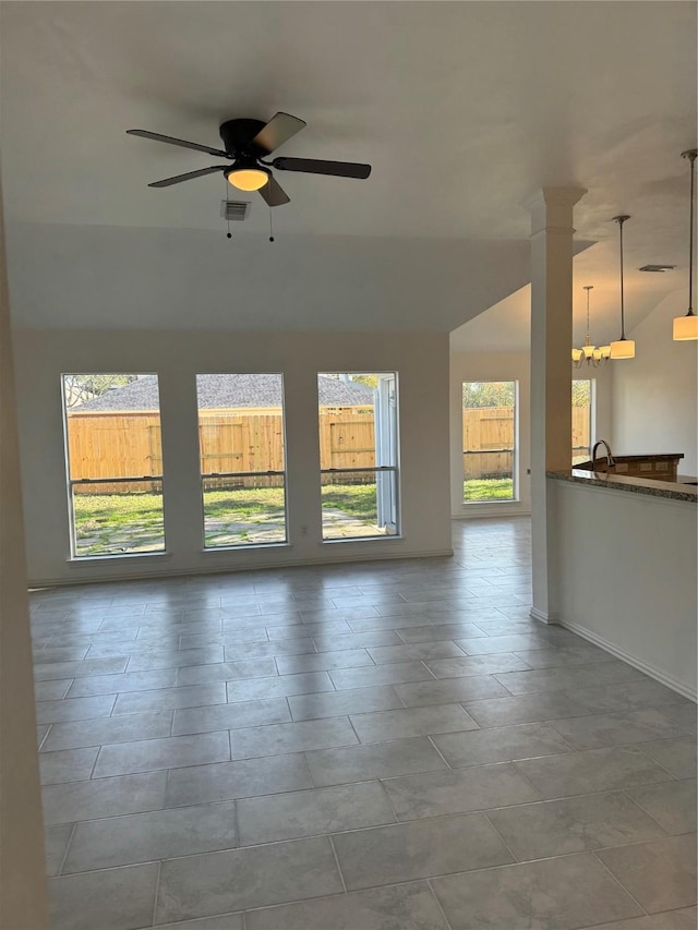 spare room featuring ceiling fan with notable chandelier, a healthy amount of sunlight, and sink