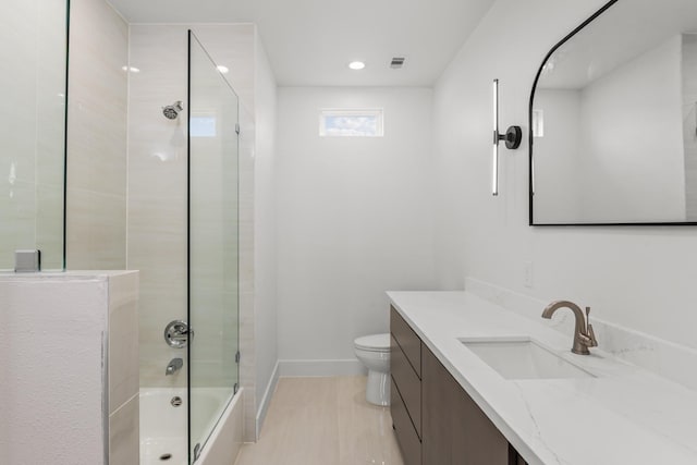 full bathroom featuring toilet, vanity, and combined bath / shower with glass door