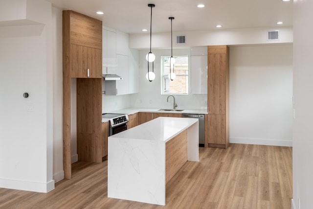 kitchen featuring sink, white cabinets, a center island, dishwasher, and hanging light fixtures