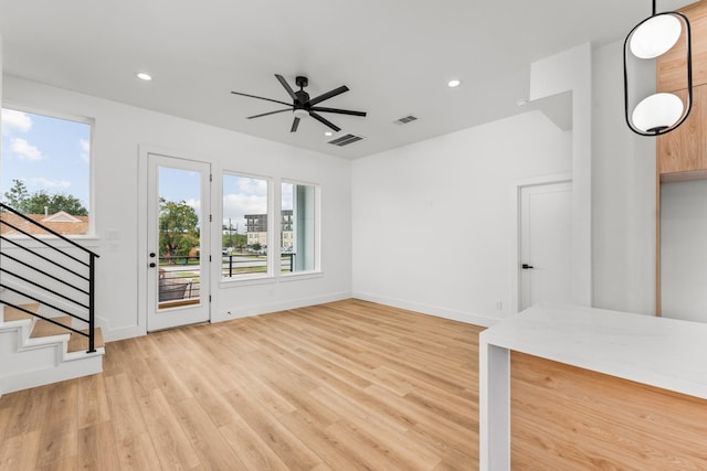 unfurnished living room featuring ceiling fan and light wood-type flooring