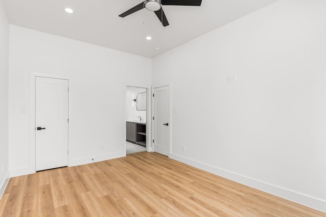 unfurnished bedroom with ceiling fan, light hardwood / wood-style floors, and connected bathroom