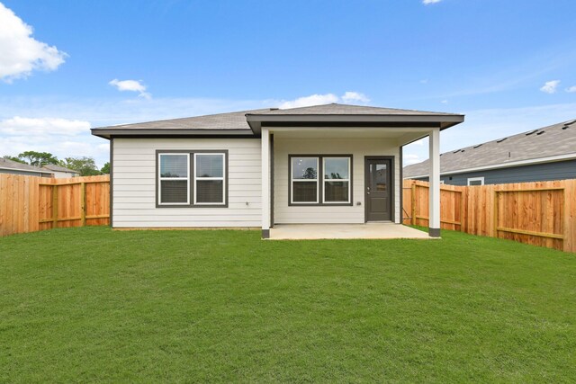rear view of house featuring a fenced backyard, a yard, and a patio area