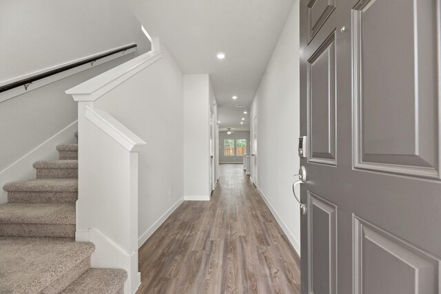 foyer with baseboards, recessed lighting, wood finished floors, and stairway
