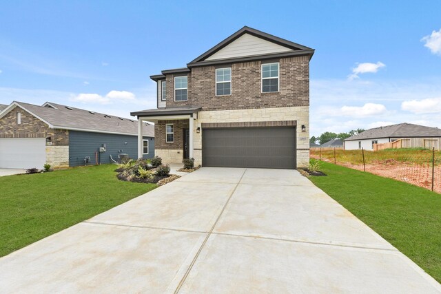 craftsman house featuring stone siding, an attached garage, concrete driveway, brick siding, and a front lawn