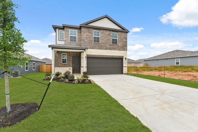 view of front facade with fence, stone siding, driveway, a front yard, and a garage