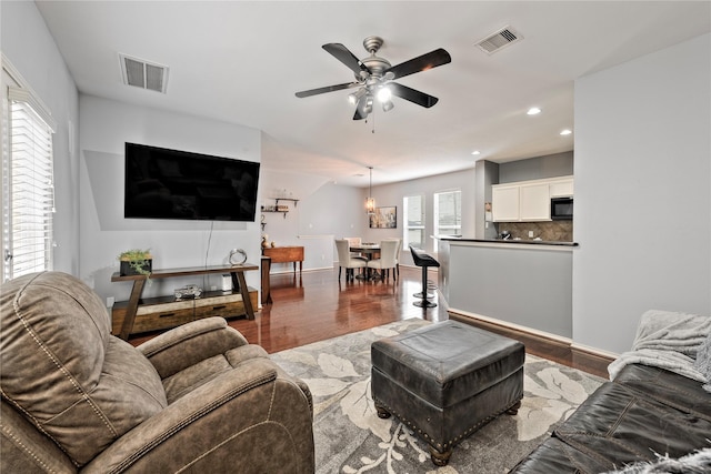 living room with ceiling fan and wood-type flooring