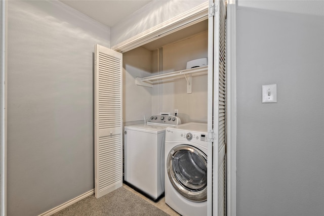 laundry room with washer and dryer and light carpet