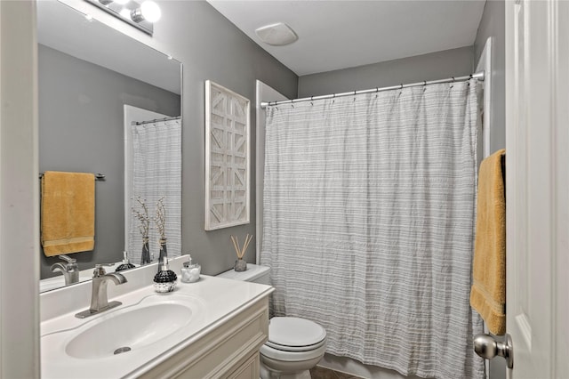 bathroom featuring toilet, vanity, and curtained shower