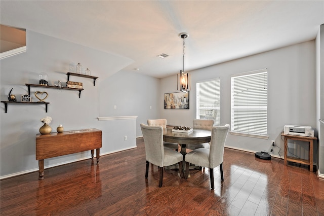 dining area featuring a notable chandelier and dark hardwood / wood-style flooring