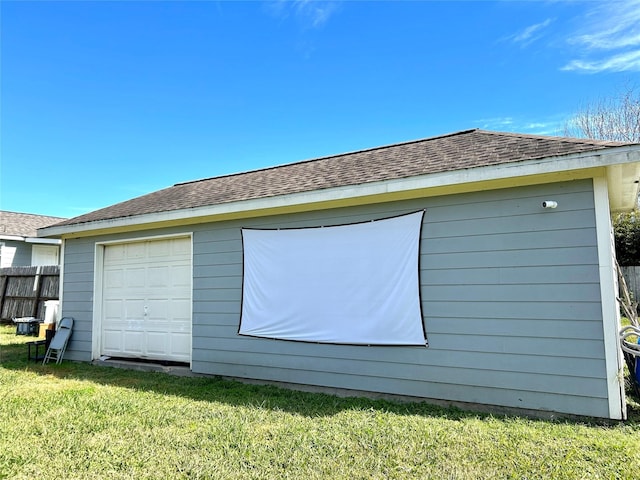 view of side of property featuring a garage, an outdoor structure, and a lawn