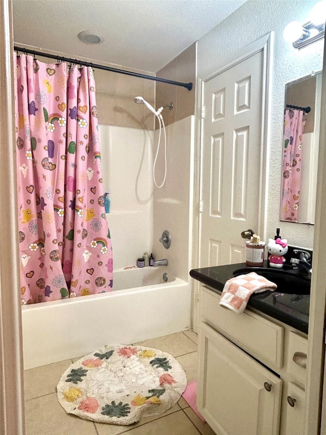 bathroom featuring a textured ceiling, tile patterned flooring, shower / bath combo with shower curtain, and vanity