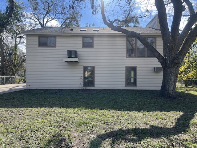 back of property with a lawn and a wall mounted AC