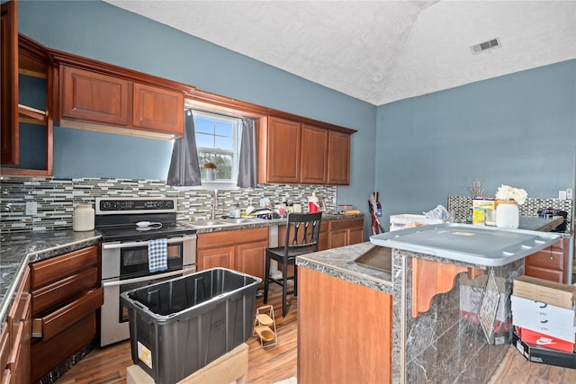 kitchen with double oven range, a kitchen island, and sink