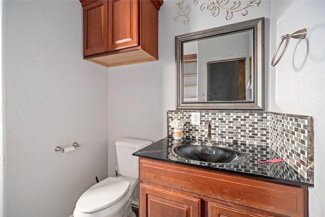 bathroom featuring toilet, vanity, and decorative backsplash