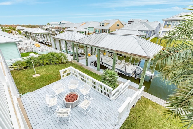 exterior space featuring a lawn, a fire pit, and a water view