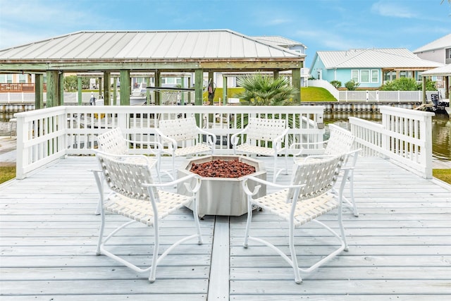 wooden deck featuring an outdoor fire pit, a gazebo, and a water view