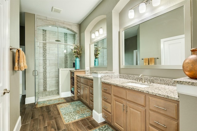 bathroom with a shower with door and vanity