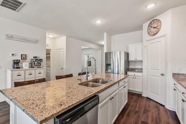 kitchen featuring dark wood-style flooring, a sink, visible vents, white cabinets, and appliances with stainless steel finishes