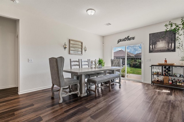 dining room with dark wood-style floors, visible vents, and baseboards