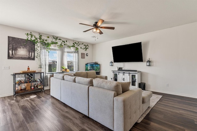 living room with dark wood-style floors, ceiling fan, and baseboards