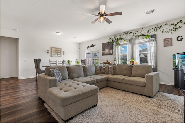 living room with a ceiling fan, baseboards, visible vents, and dark wood-style flooring