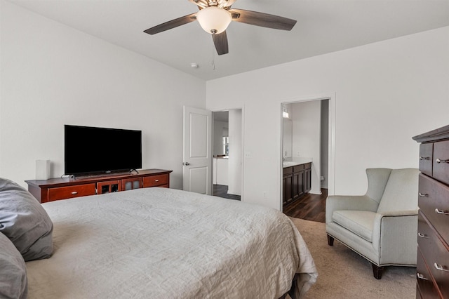 bedroom featuring ceiling fan, ensuite bath, and wood finished floors